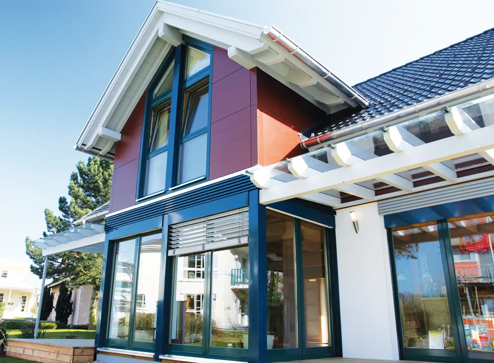Casa con fachada granate y blanca y ventanas y puertas de PVC azules