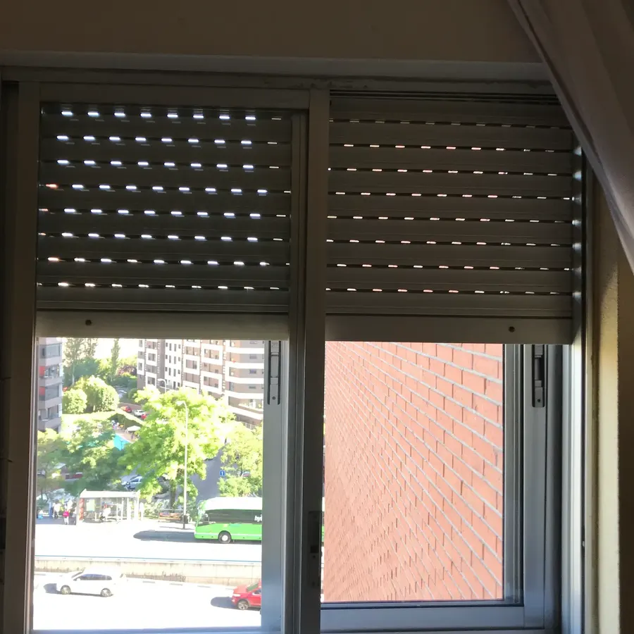 Antes: ventana corredera de aluminio con persiana exterior en un dormitorio de Madrid