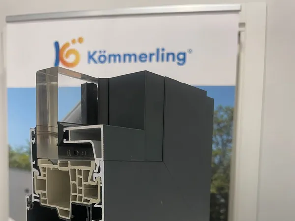 Muestra cortada del perfil Kömmerling AluNext con el aluminio exterior en gris oscuro