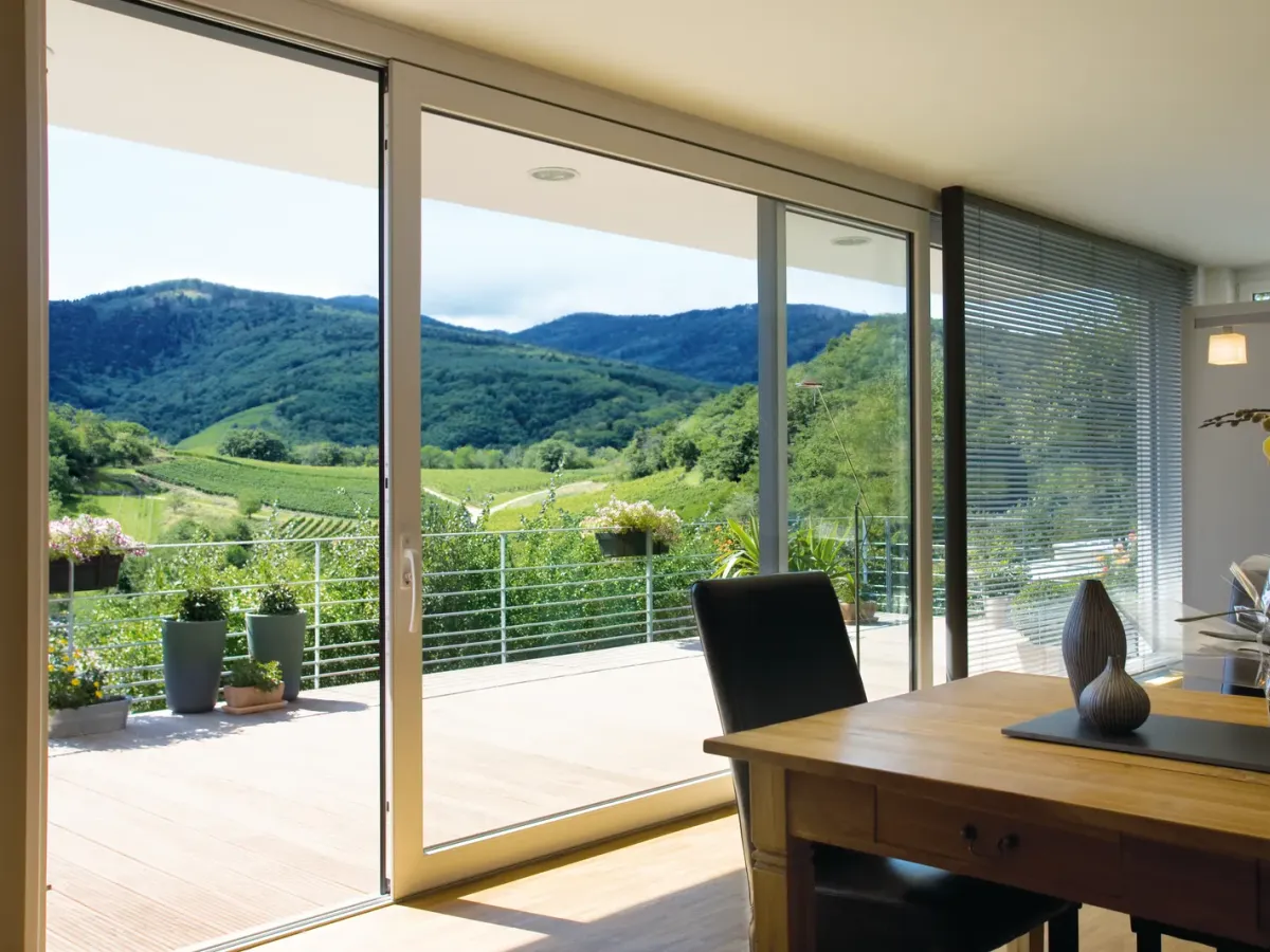 Comedor con una corredera de suelo a techo abierta a una terraza con vistas