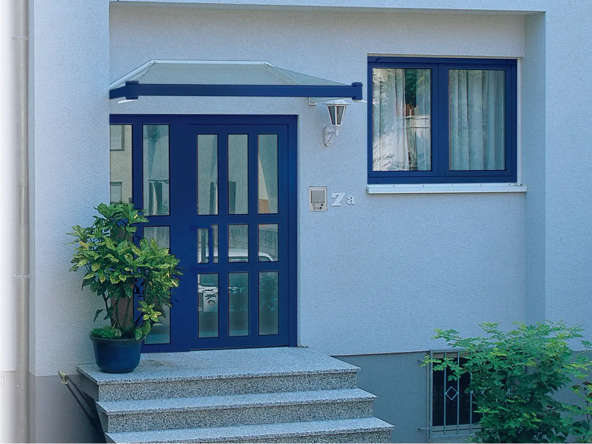 Puerta de entrada de PVC azul con vidrieras y ventana a juego