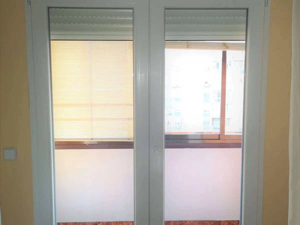 Balconera de PVC blanca de dos hojas con cajón de persiana encima